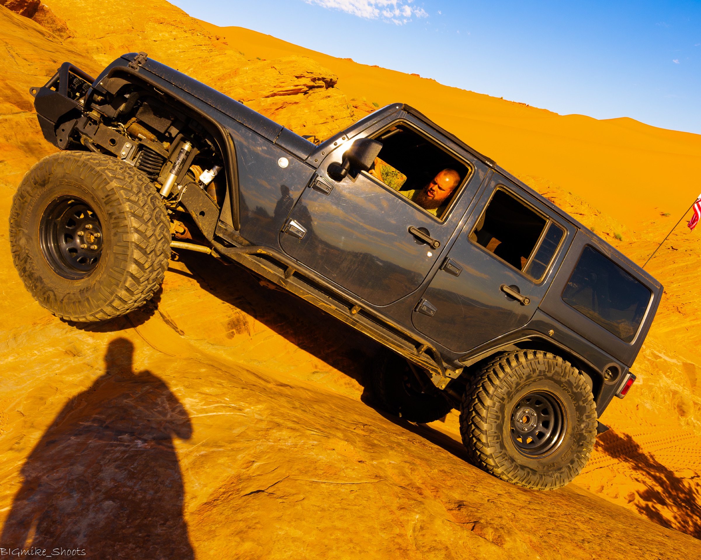 Jeep at full articulation on slickrock