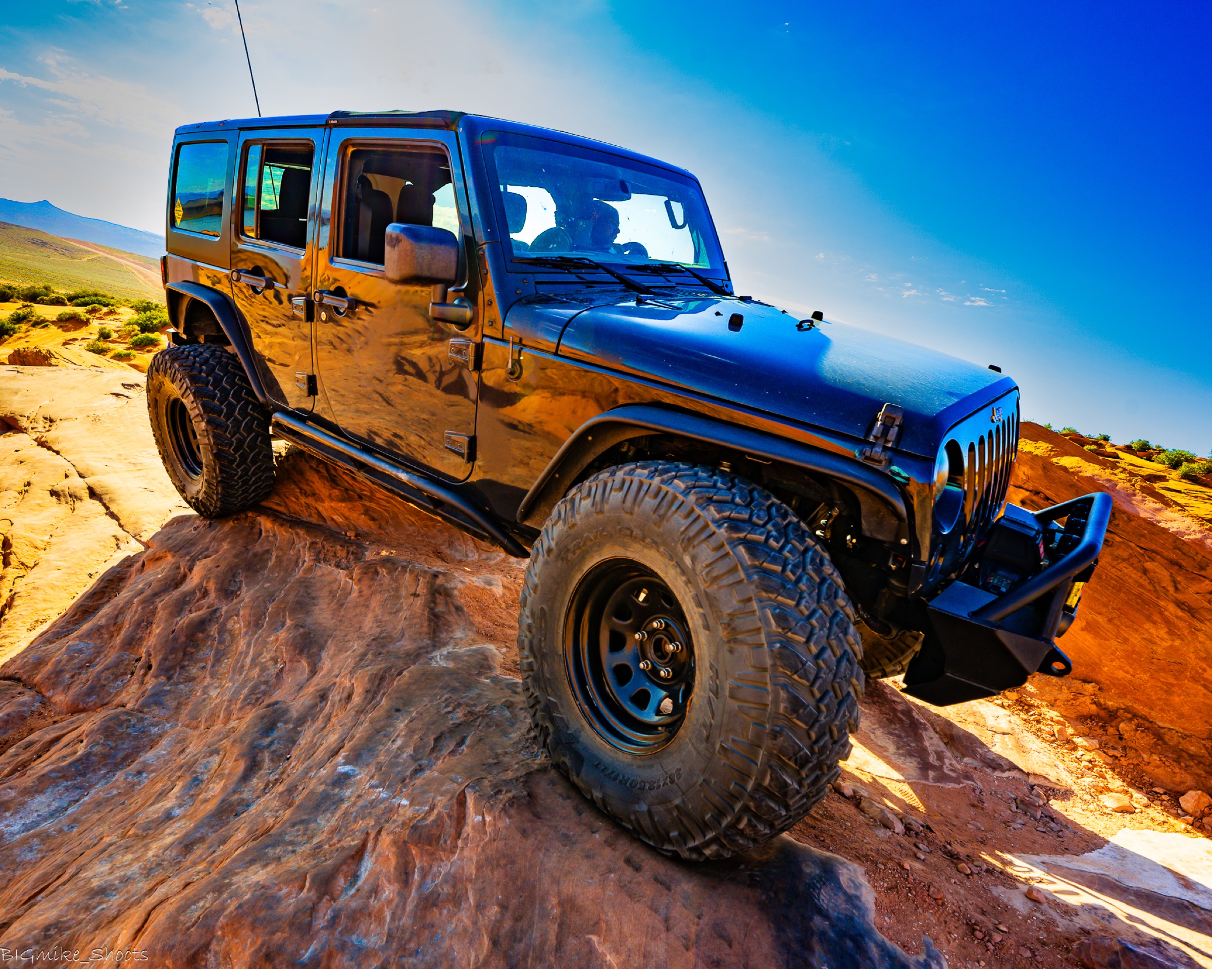 Jeep climbing red rock at golden hour