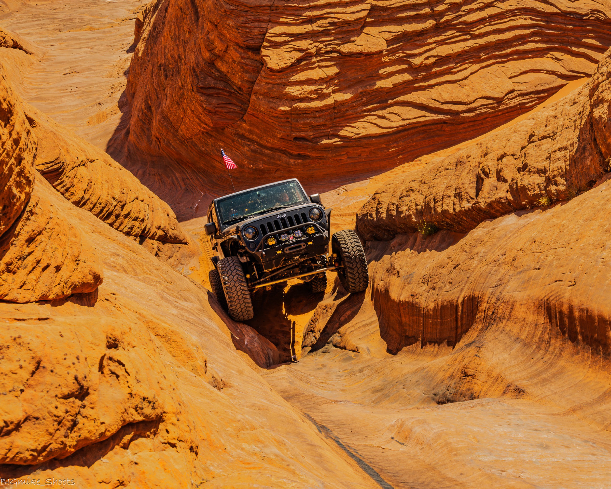 Jeep dwarfed inside a slickrock bowl